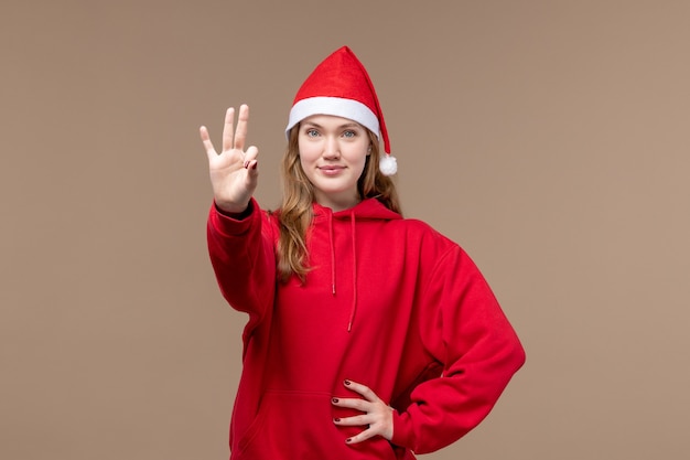 Front view young female showing number on brown background emotion christmas holiday