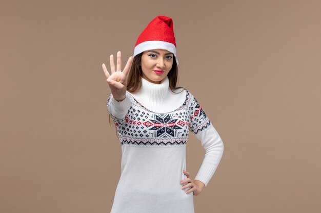 Front view young female showing number on brown background holiday christmas emotion