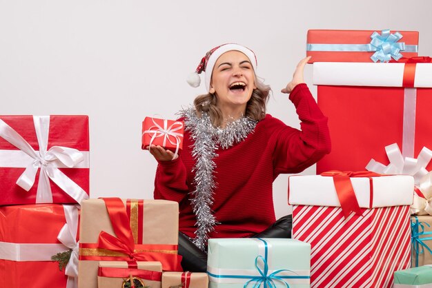 Front view young female sitting around christmas presents