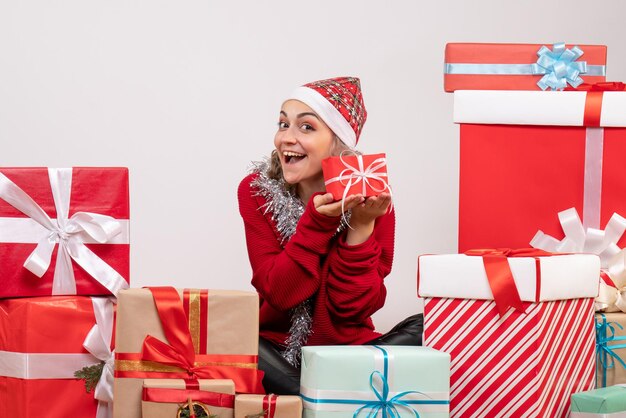 Front view young female sitting around christmas presents