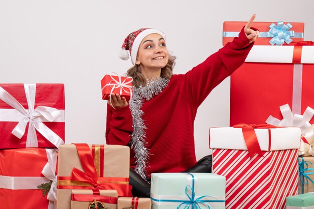 Front view young female sitting around christmas presents