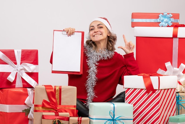 Front view young female sitting around christmas presents