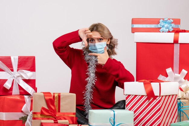 Front view young female sitting around christmas presents