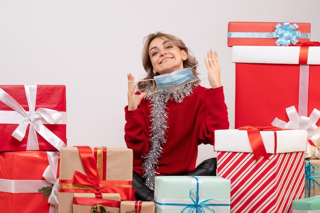 Front view young female sitting around christmas presents