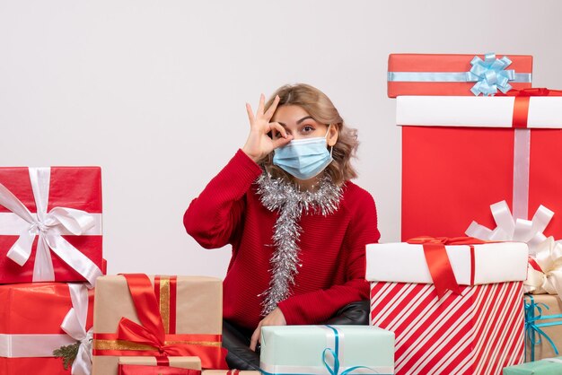 Front view young female sitting around christmas presents