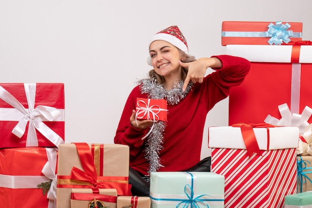 Front view young female sitting around christmas presents