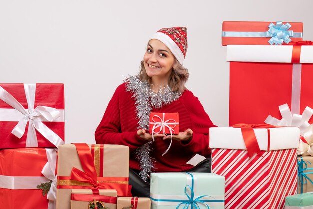 Front view young female sitting around christmas presents