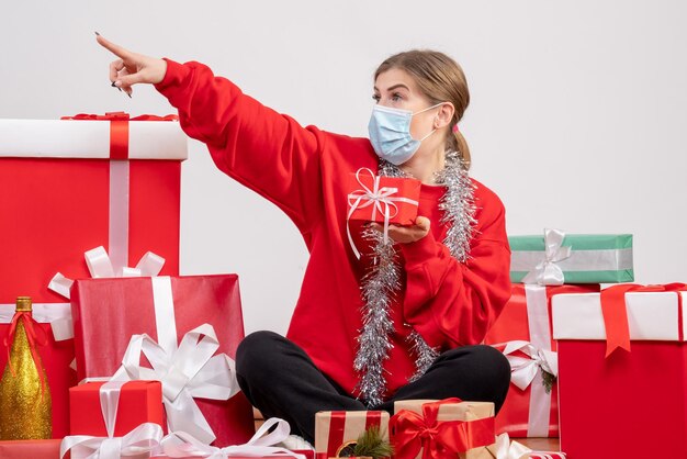 Front view young female sitting around christmas presents