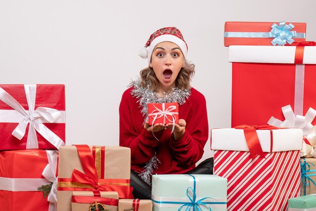 Front view young female sitting around christmas presents