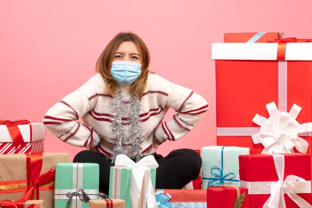 Front view young female sitting around christmas presents