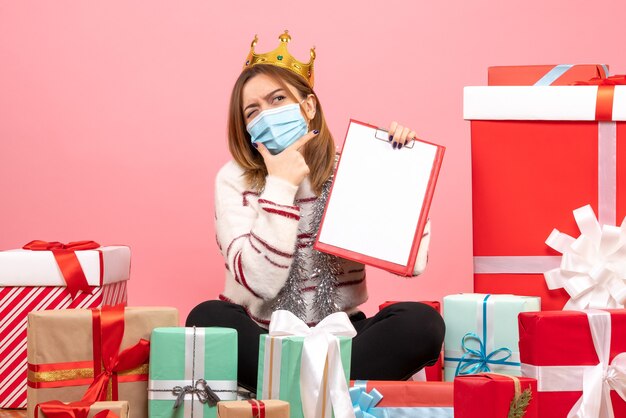 Front view young female sitting around christmas presents