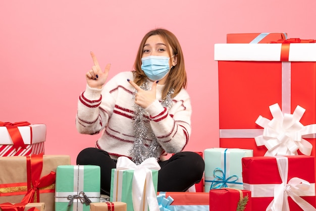 Front view young female sitting around christmas presents