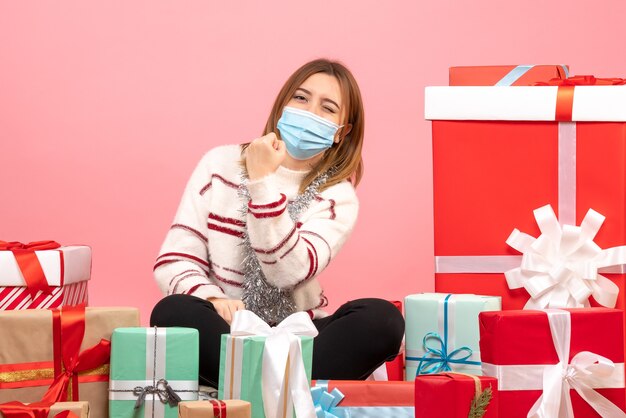 Front view young female sitting around christmas presents