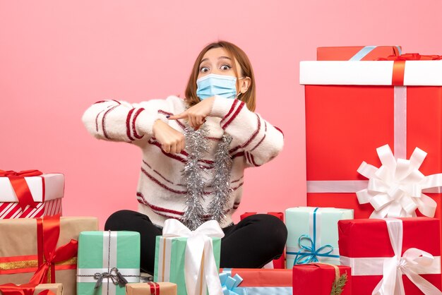 Front view young female sitting around christmas presents