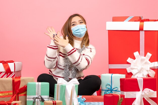 Front view young female sitting around christmas presents