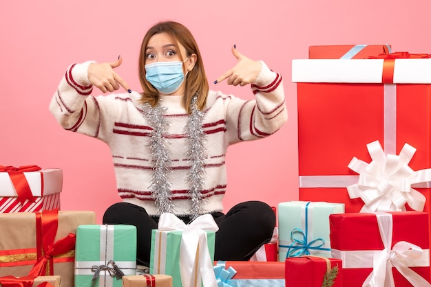 Free photo front view young female sitting around christmas presents