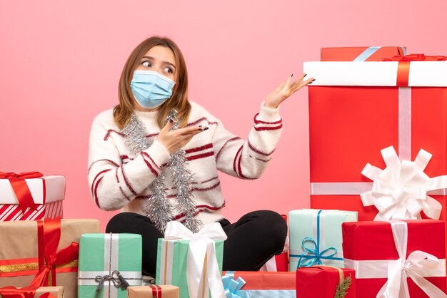 Front view young female sitting around christmas presents