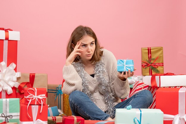 Front view young female sitting around different presents