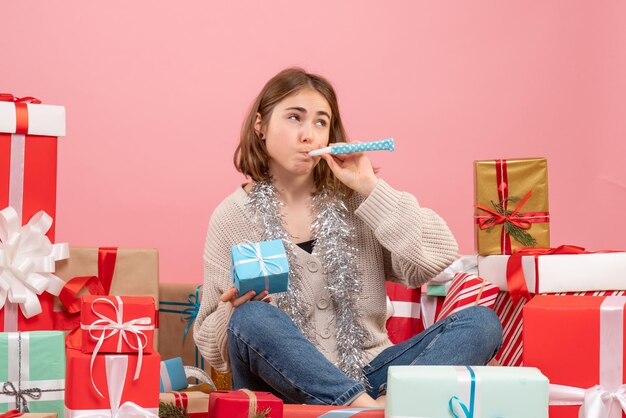 Front view young female sitting around different presents