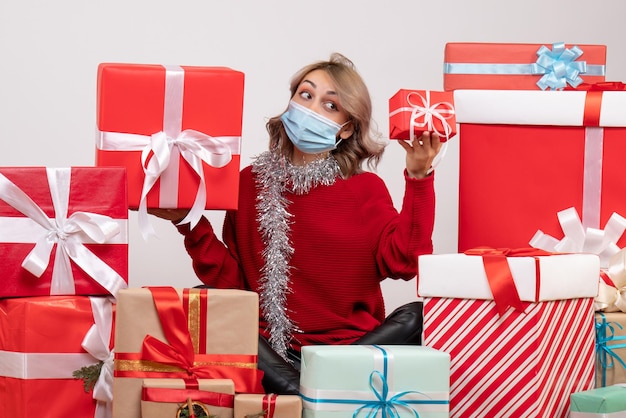 Front view young female sitting around different presents