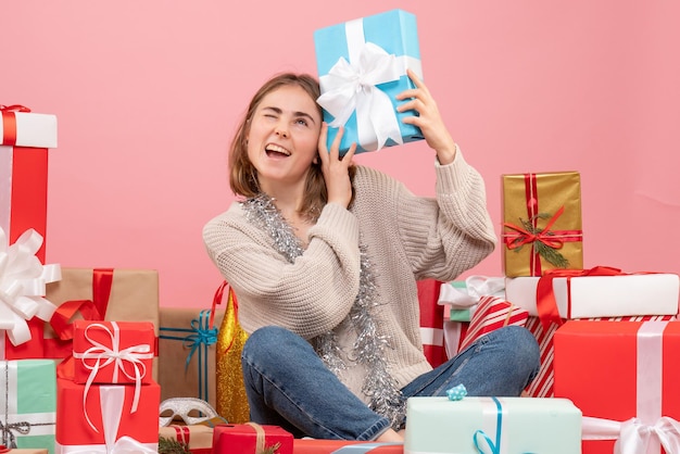 Front view young female sitting around different xmas presents