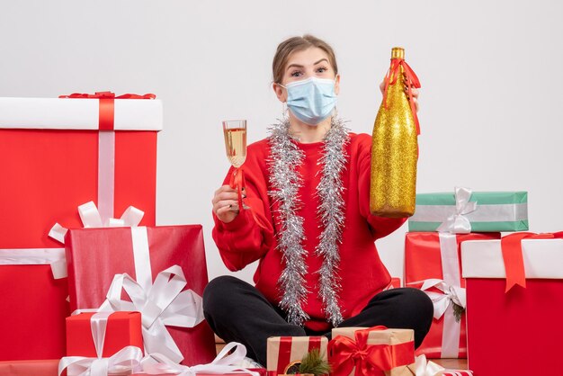 Free photo front view young female sitting around presents celebrating with champagne