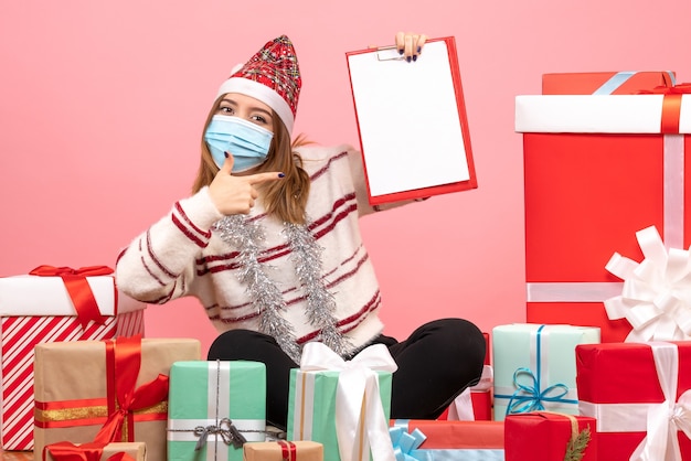 Free photo front view young female sitting around presents with file note