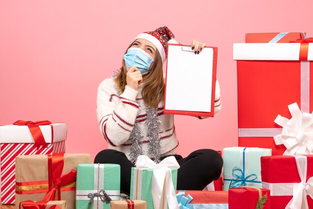 Free photo front view young female sitting around presents with file note