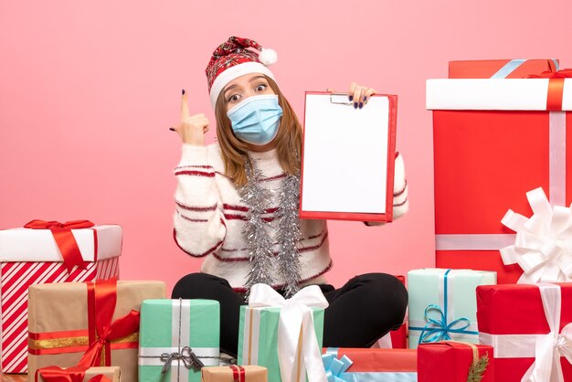 Front view young female sitting around presents with file note