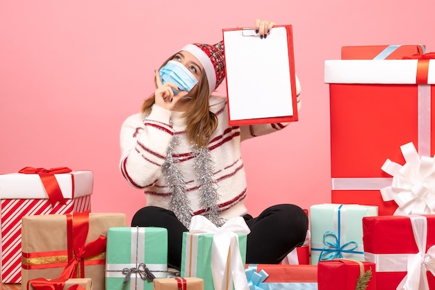 Free photo front view young female sitting around presents with file note