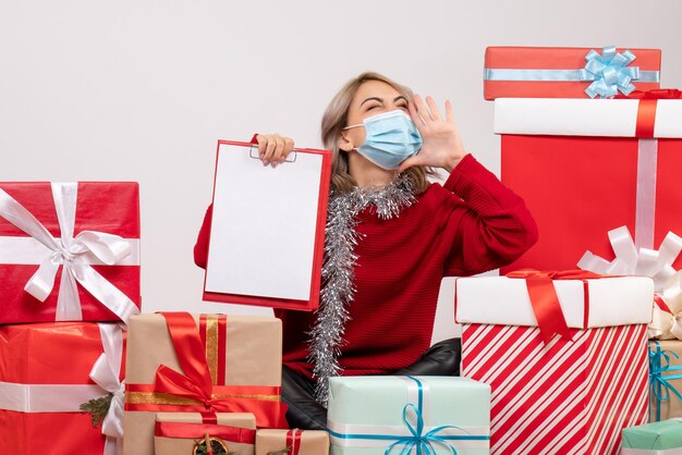 Front view young female sitting around presents with note