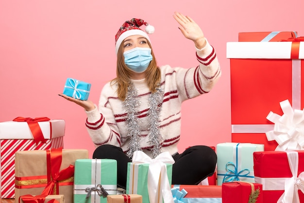 Front view young female sitting around presents