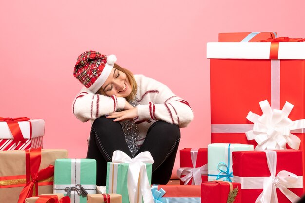 Front view young female sitting around presents