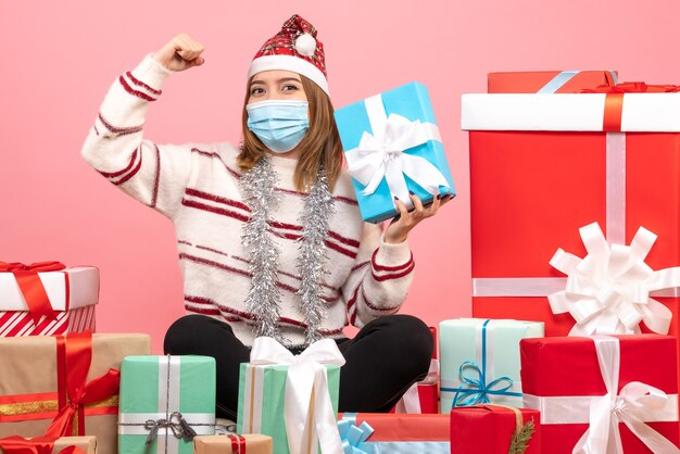 Front view young female sitting around presents