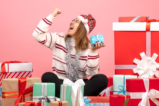 Front view young female sitting around xmas presents