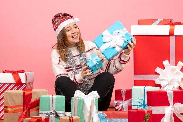 Front view young female sitting around xmas presents