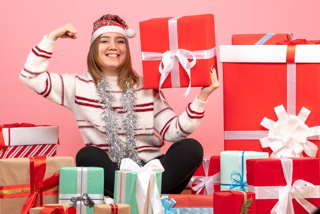 Front view young female sitting around xmas presents