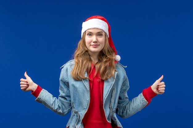 Giovane femmina di vista frontale che sorride sul colore blu di emozioni di natale del fondo