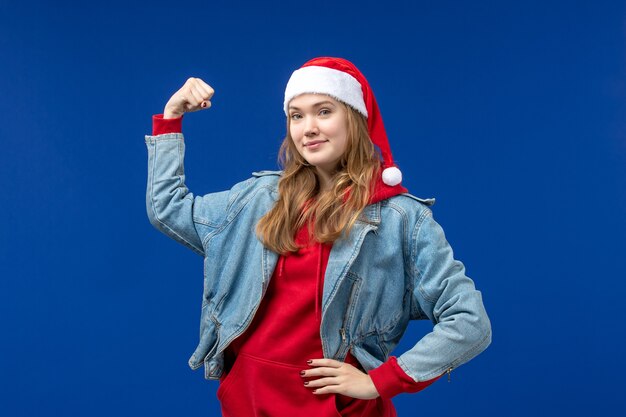 Front view young female smiling and flexing on blue background emotion christmas holiday color