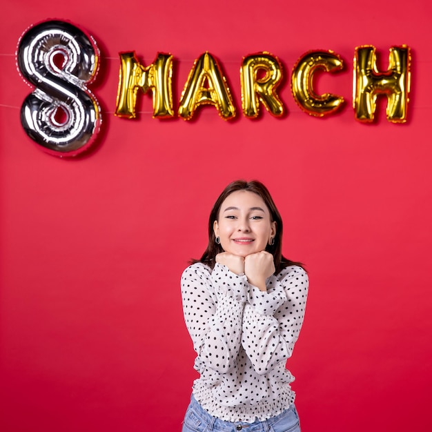 Front view young female smiling on march decorated red background passion love woman horizontal equality feminine affectionate holiday beauty