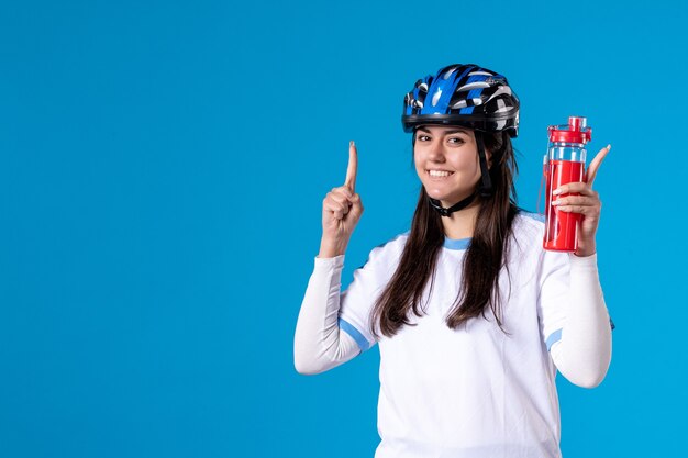 Front view young female in sport clothes and helmet on blue wall