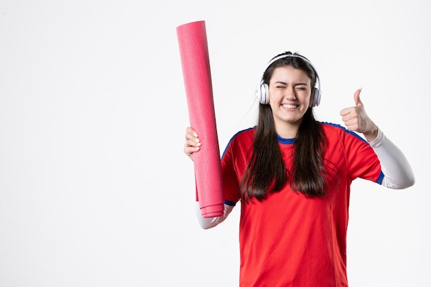 Front view young female in sport clothes holding yoga mat