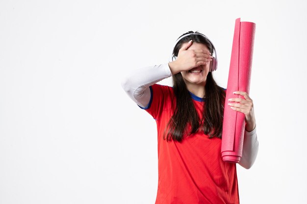 Front view young female in sport clothes holding yoga mat