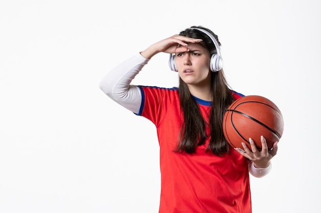 Free photo front view young female in sport clothes with basketball on white wall