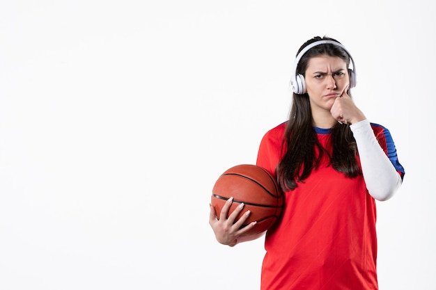 バスケットボールの白い壁とスポーツ服を着た若い女性の正面図