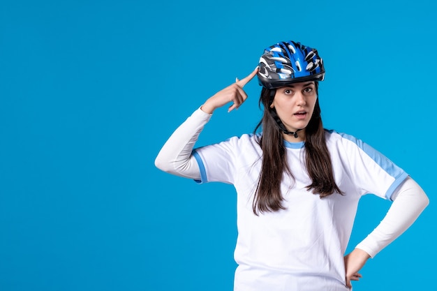 파란색 벽에 헬멧 스포츠 옷 전면보기 젊은 여성
