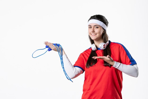 Front view young female in sport clothes with skipping ropes on white wall