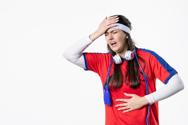 Front view young female in sport clothes with skipping ropes on white wall