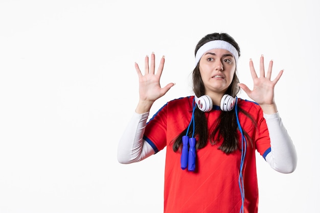 Front view young female in sport clothes with skipping ropes on white wall