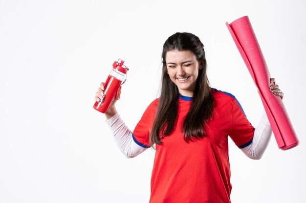 Front view young female in sport clothes with yoga mat on white wall